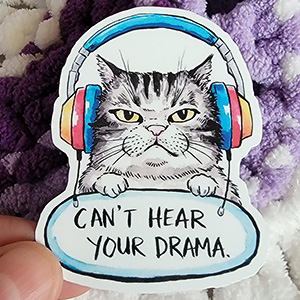 Illustration of a grumpy cat wearing colorful headphones with a sign that reads "Can't Hear Your Drama."