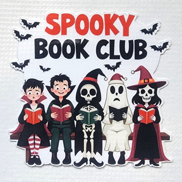 A vinyl sticker of spooky characters, including a witch, ghost, skeleton, and vampires, reading books with bats flying above.