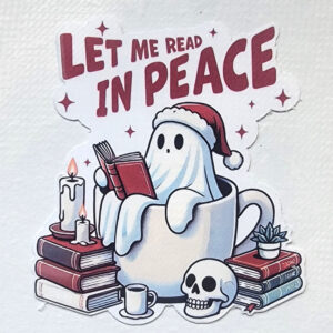 A vinyl sticker of a ghost in a Santa hat reading in a coffee mug, surrounded by books, candles, and a skull.