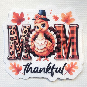 Illustration of a cute turkey in a pilgrim hat with "MOM" in patterned letters and "thankful" below, featuring leopard print, buffalo plaid, and autumn leaves.